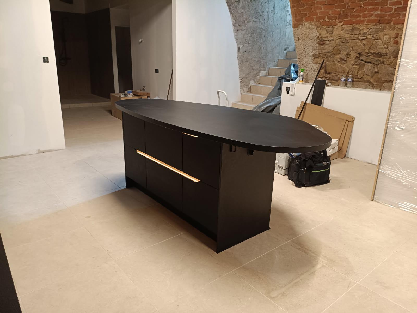Îlot de cuisine noir avec mur en pierre